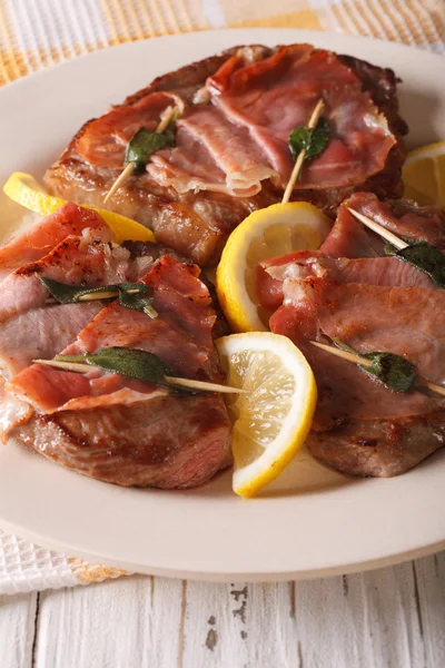 Итальянская говядина Saltimbocca с шалфеем, ветчиной и лимоном крупным планом. Верт — стоковое фото