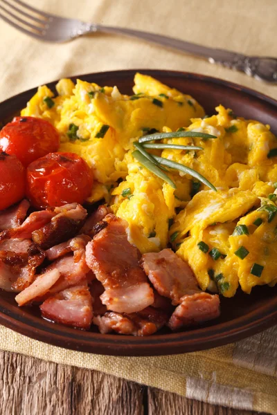 Scrambled eggs and chives, fried bacon close-up. Vertical — Stock Photo, Image