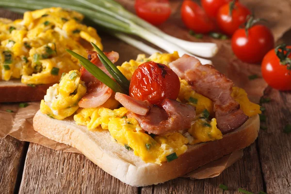 Sandwich with scrambled eggs, bacon, green onions and tomatoes c — Stock Photo, Image