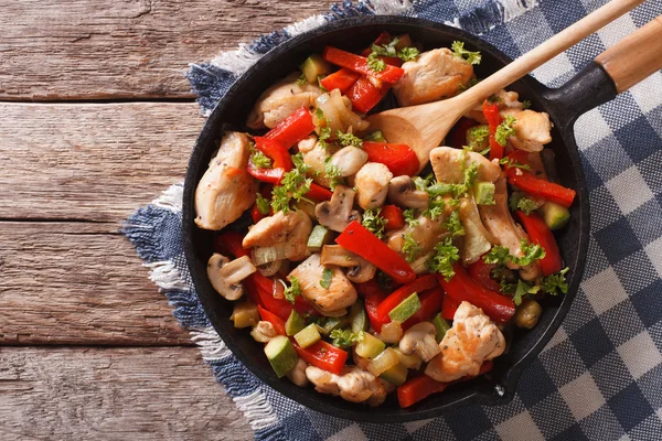 Mexer frango frito com cogumelos, pimentas e abobrinha em uma panela c — Fotografia de Stock