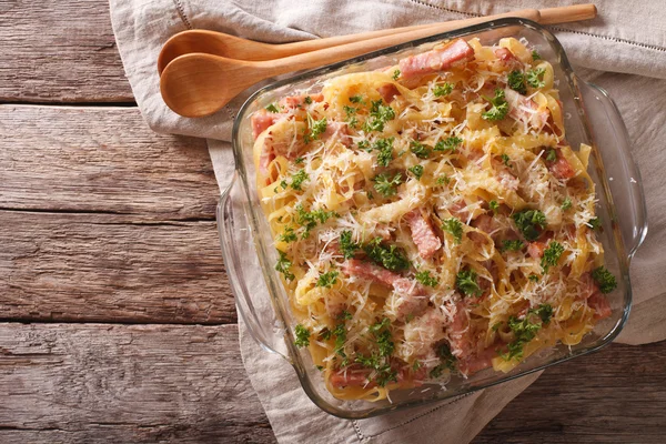 Noodles baked with ham and cheese close-up in a baking dish. hor — Stock Photo, Image