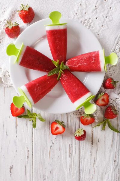 Strawberry ice cream with mint on a stick closeup. Vertical top — Stock Photo, Image