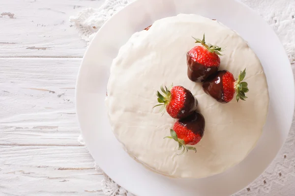 Tårta med vit glasyr och jordgubbar i choklad närbild. hor — Stockfoto