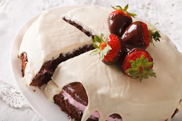 Chocolate cake met witte icing en aardbeien close-up. HORIZ — Stockfoto