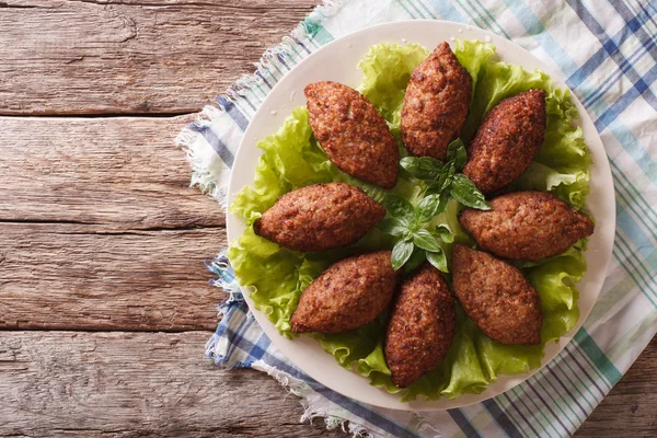 Arabic cuisine: meat appetizer kibbeh closeup on a plate. Horizo