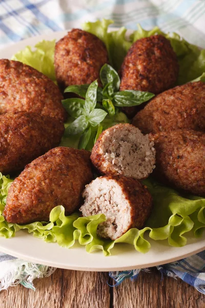 Arabic kibbeh with bulgur and pine nuts on a plate macro. vertic — Stock Photo, Image