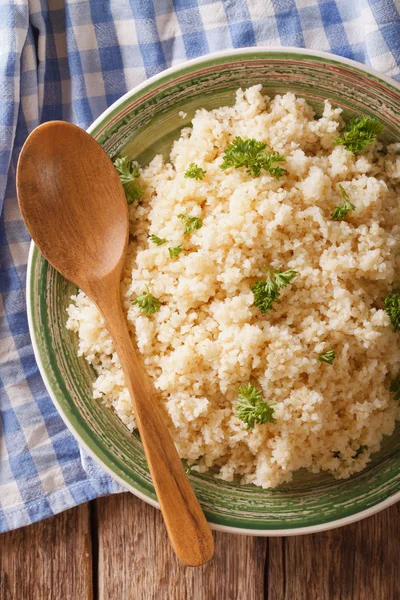 Nützlicher Bulgur mit Petersilie in Großaufnahme auf einem Teller auf dem Tisch. Mehr — Stockfoto