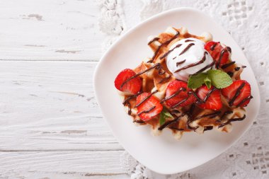 Belgian waffles with strawberries and chocolate topping. Horizon