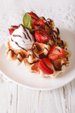 Belgian waffles with strawberries, whipped cream and chocolate c