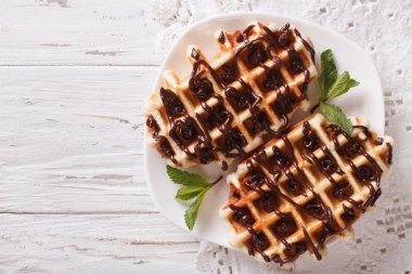 Dessert waffles with chocolate topping on a plate. Horizontal to clipart