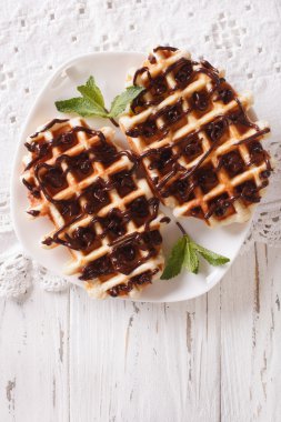 Belçika waffle'ları ve çikolatalı bir tabak yakın çekim. dikey üst