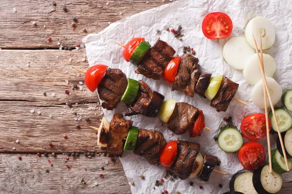 Smakelijke kebab met groenten op spiesjes close-up. horizontale boven — Stockfoto