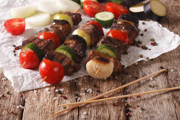 Roasted meat with vegetables on skewers close-up. horizontal — Stock Photo, Image