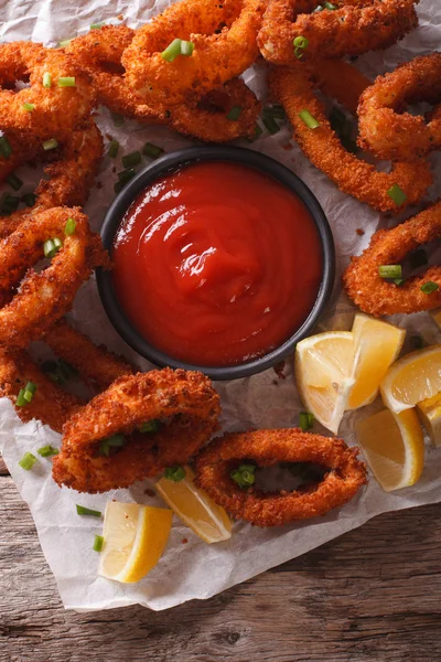 Вкусные жареные кольца кальмаров крупным планом на столе, и томатный соус — стоковое фото