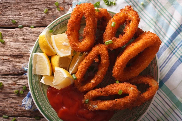 Stekte kalamariseringer tett sammen med ketchup og sitron. Horisontal – stockfoto