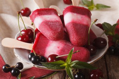Masaya yakın çekim bir sopa üzerinde nane ve kiraz ile popsicle. 
