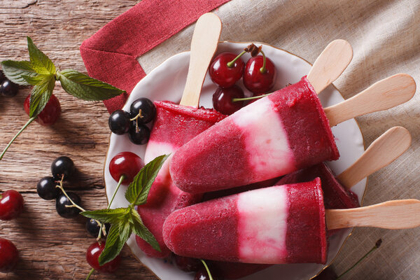 Tasty berry sorbet with mint on a stick closeup on the table. Ho