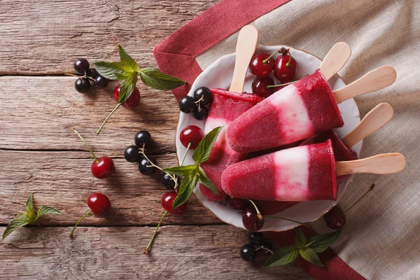 Masada yakın çekim bir sopa üzerinde kiraz ile popsicle. horizonta