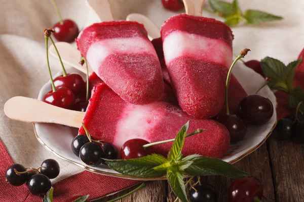 Popsicle with mint and cherry on a stick close-up on the table. — Stock Photo, Image