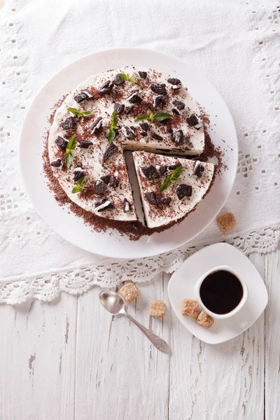 Cheesecake with pieces of chocolate cookies and coffee closeup. — Stock Photo, Image