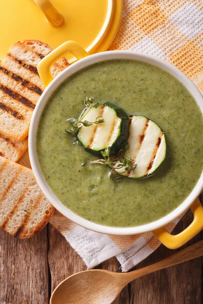 Zucchini soup close-up in yellow saucepan and toast. vertical to — Stock Photo, Image