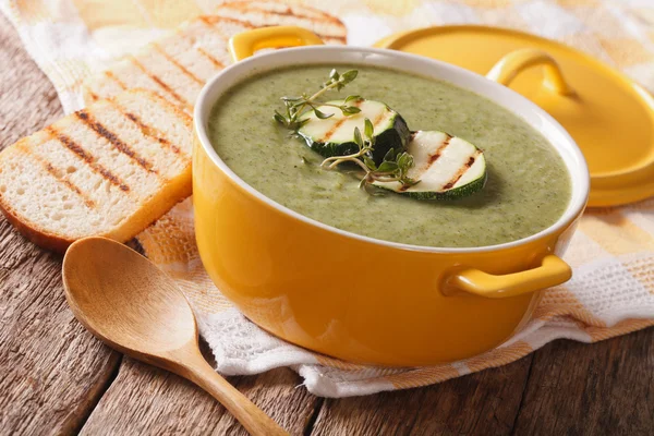 Zucchini soup close-up in yellow saucepan and toast. Horizontal — Stock Photo, Image