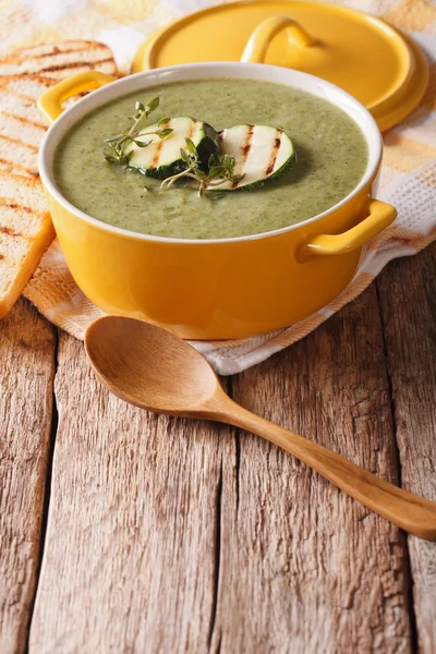 Zucchini soup close-up in yellow saucepan and toast. vertical — Stock Photo, Image