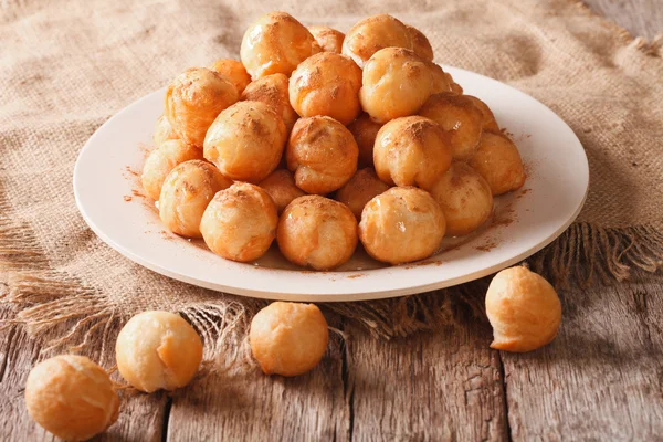 Små donuts med honung och kanel på bordet. horisontella — Stockfoto