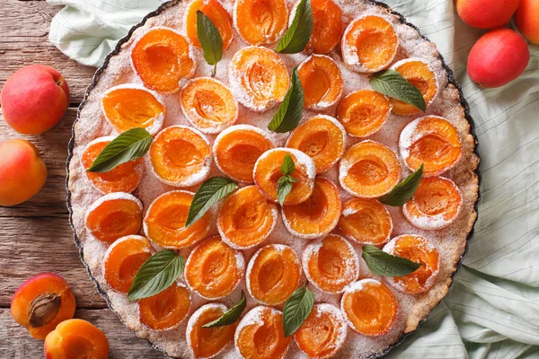 Leckere Torte mit frischen Aprikosen verziert mit Minze in Nahaufnahme. hor — Stockfoto