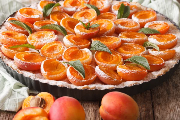 Leckere Torte mit frischen Aprikosen verziert mit Minze in Nahaufnahme. hor — Stockfoto