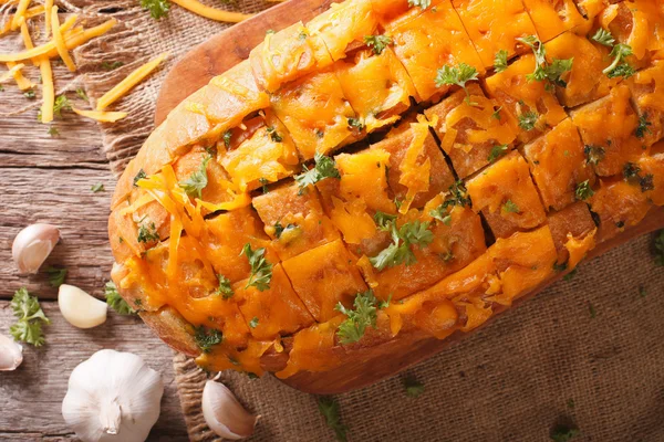 Pão de queijo Cheddar com alho e ervas closeup na mesa . — Fotografia de Stock