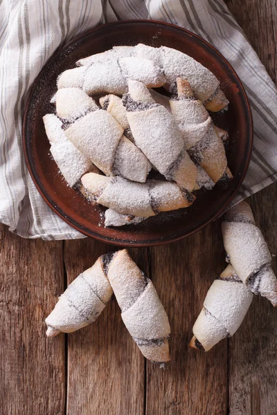 Crescent rolls with poppy seeds macro on a plate. Vertical top v — Stock Photo, Image