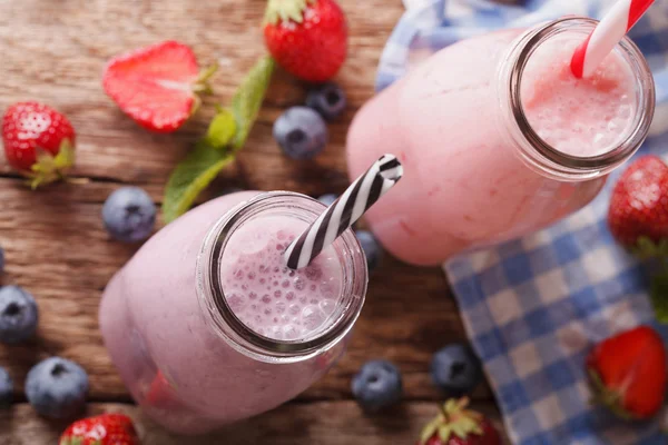 Smoothie met aardbeien en blauwe bessen in flessen close-up. H — Stockfoto