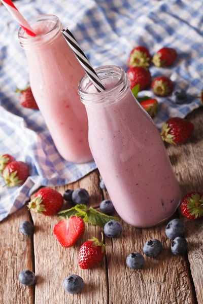 Frullato con fragole e mirtilli in bottiglia primo piano . — Foto Stock