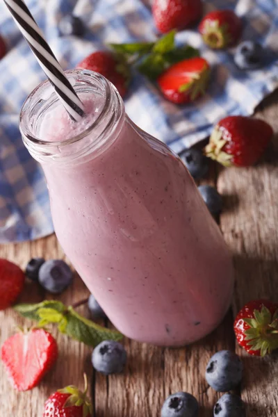 Batido de leche con fresas y arándanos en una botella de vidrio —  Fotos de Stock