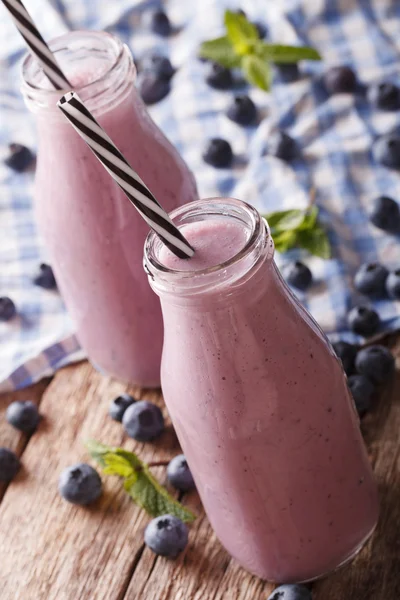 Smakelijke blueberry melk drank met munt in glazen flessen sluiten-u — Stockfoto