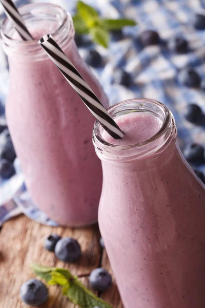 Koude blueberry smoothie met munt in een glazen fles macro. Verti — Stockfoto