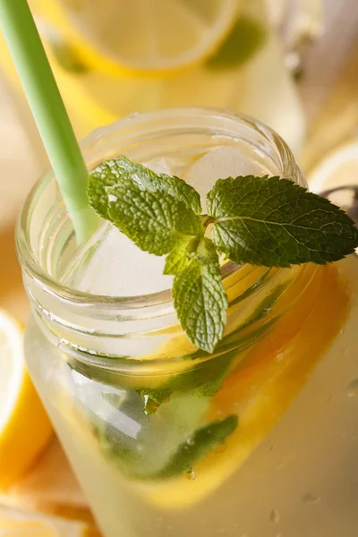 Koude limonade met ijs en munt macro in een pot. verticale — Stockfoto