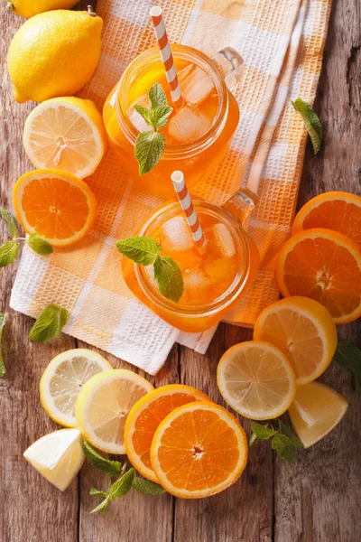 Verse cocktail met sinaasappelen, citroenen, ijs en munt in een glazen pot — Stockfoto