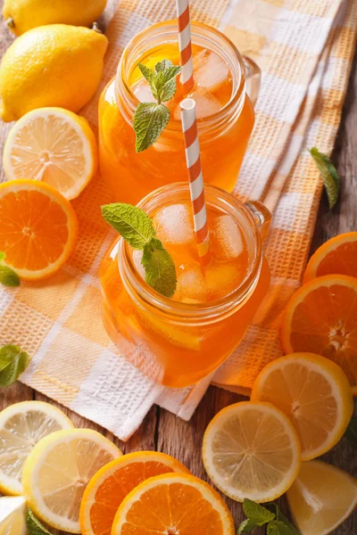 Jus d'orange savoureux avec citron, glace et menthe en gros plan sur la table — Photo