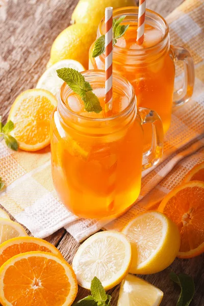 Velsmagende appelsinjuice med citron, is og mynte close-up. lodret - Stock-foto