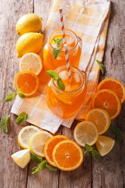 Kold orange drink med citron, mynte og is close-up. Lodret til - Stock-foto