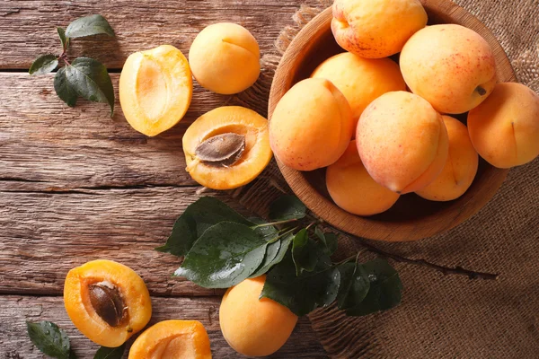 Fresh apricots in a wooden bowl on the table close-up. horizonta — Stock Photo, Image
