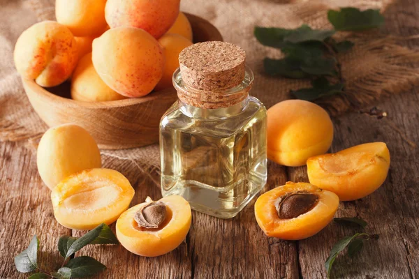 Apricot kernel olie in een glazen pot close-up en ingrediënten. HORIZ — Stockfoto