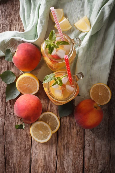 Perzik limonade met ijs en munt close-up in een glazen pot. Vertic — Stockfoto