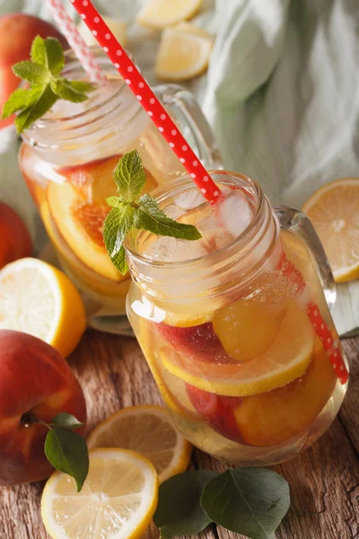 Zelfgemaakte limonade met perziken, ijs en munt in een glazen pot clos — Stockfoto