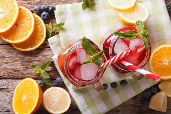 Sangria met fruit en bessen, ijs en munt close-up in een glas — Stockfoto