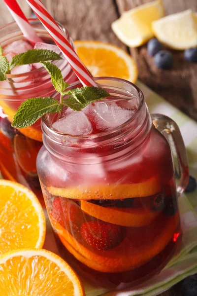 Sangria con cítricos, fresas y arándanos macro en un vaso j — Foto de Stock