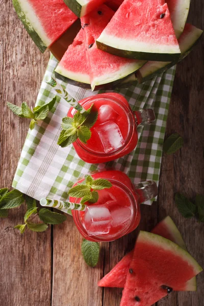 Verse watermeloen sap met ijs en Mint macro in glazen potten. Ve — Stockfoto