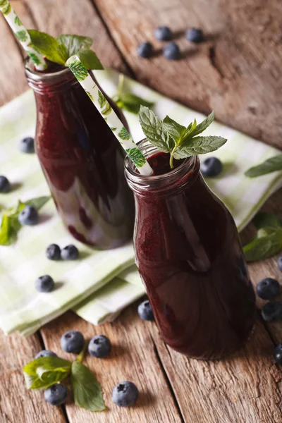 Fresh blueberry juice in a glass bottle close-up. vertical — Stock Photo, Image